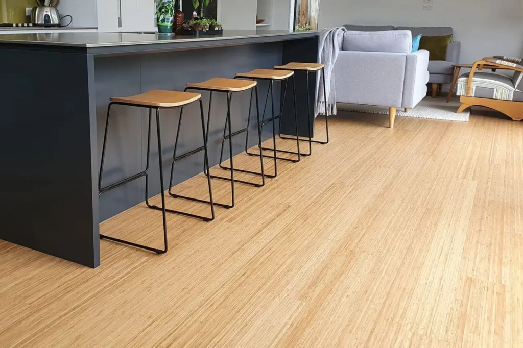 Friendly Build & Fix bamboo flooring in an open-plan kitchen and lounge with modern stools and furniture