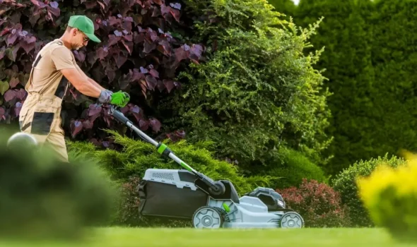 Friendly Build & Fix landscaping expert mowing a lawn to create functional outdoor spaces with professional care.