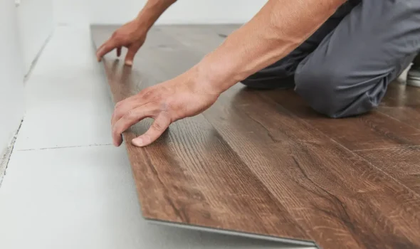 Friendly Build & Fix expert measuring and laying laminate flooring planks during precision installation