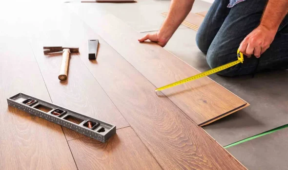 Laminate Flooring Installation by Friendly Build & Fix Friendly Build & Fix expert measuring and laying laminate flooring planks during precision installation